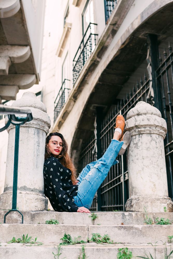 Young person sitting between pillars on street