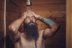 Man taking shower in wooden bathroom