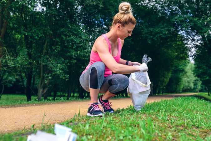 Woman picking up trash doing plogging