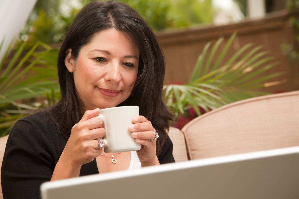 Hispanic Woman with Coffee and Laptop