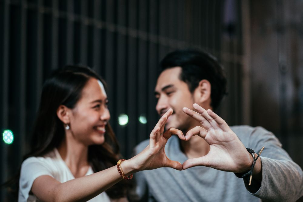 Asian couple hard making heart shape and gazing eyes together