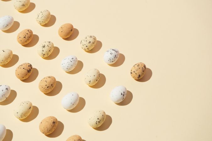 Speckled eggs  in rows on pastel yellow background