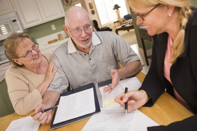Older Adult Couple Going Over Papers in Their Home with Agent