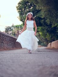 Elegant girl in white gown walking along alley