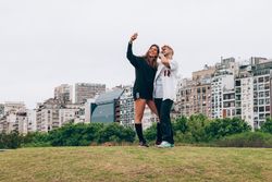 Friends smiling while making selfie on smartphone at city