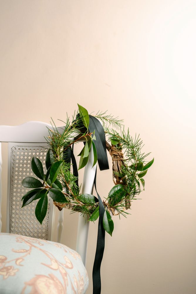 Christmas green wreath hanging on the chair, branches of pine and natural plants