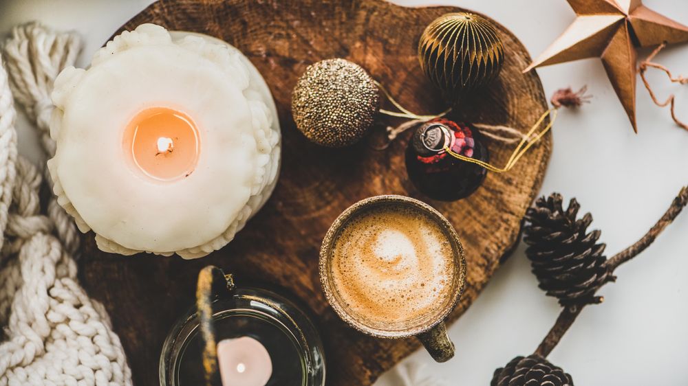 Coffee, candles, festive decorations on wooden board