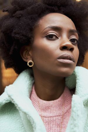 Portrait of Black woman wearing turquoise jacket