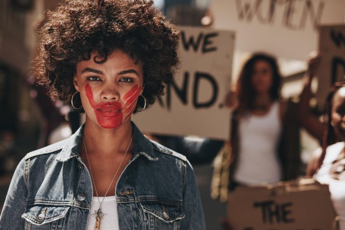 Black woman with red colored hand on her mouth during a protest