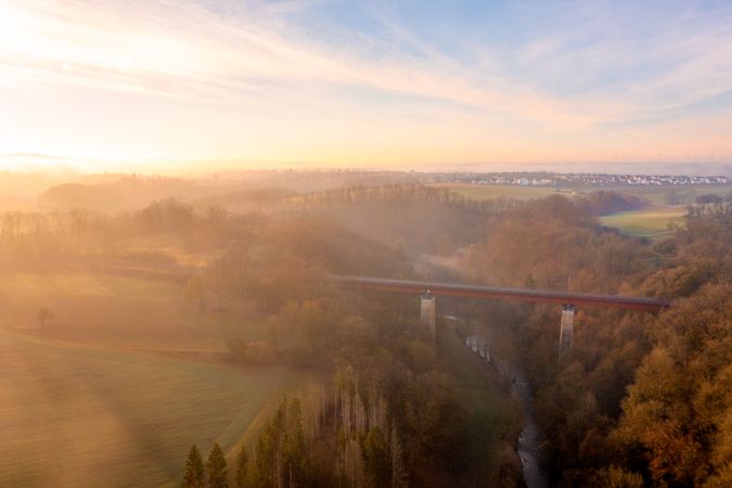 Sunrise aerial view with train bridge over river in the nature