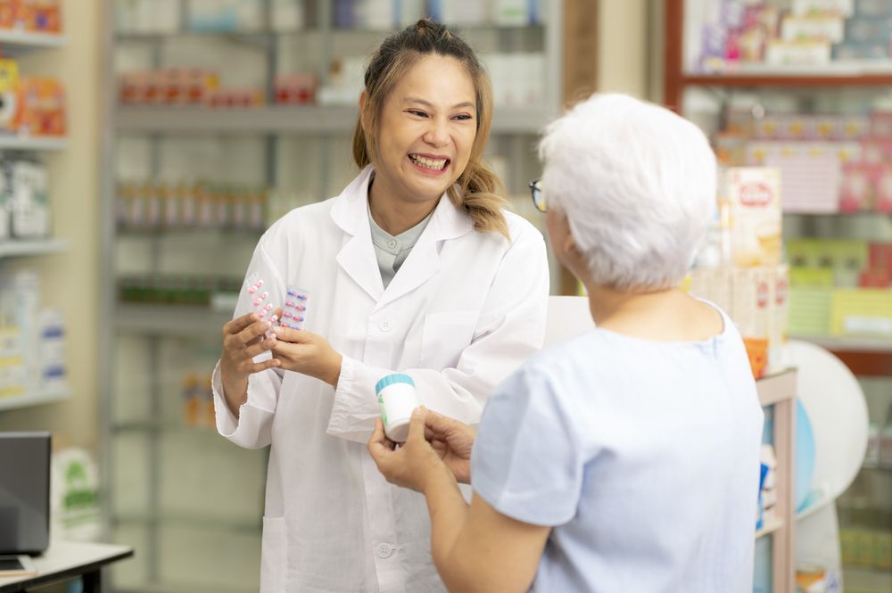Asian female pharmacist gives Indian woman medicine advice to cure ailments.