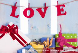 The word “love” spelled out hanging as a banner with colorful presents below bGQjx5