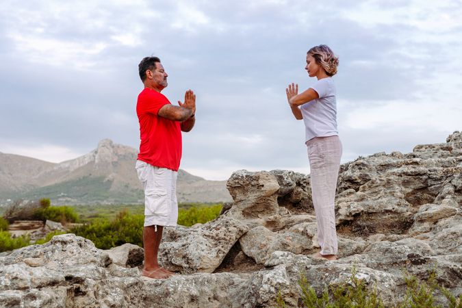 Couple meditating on rock