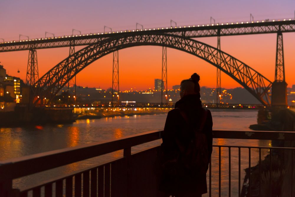 Woman looking at river and city in evening