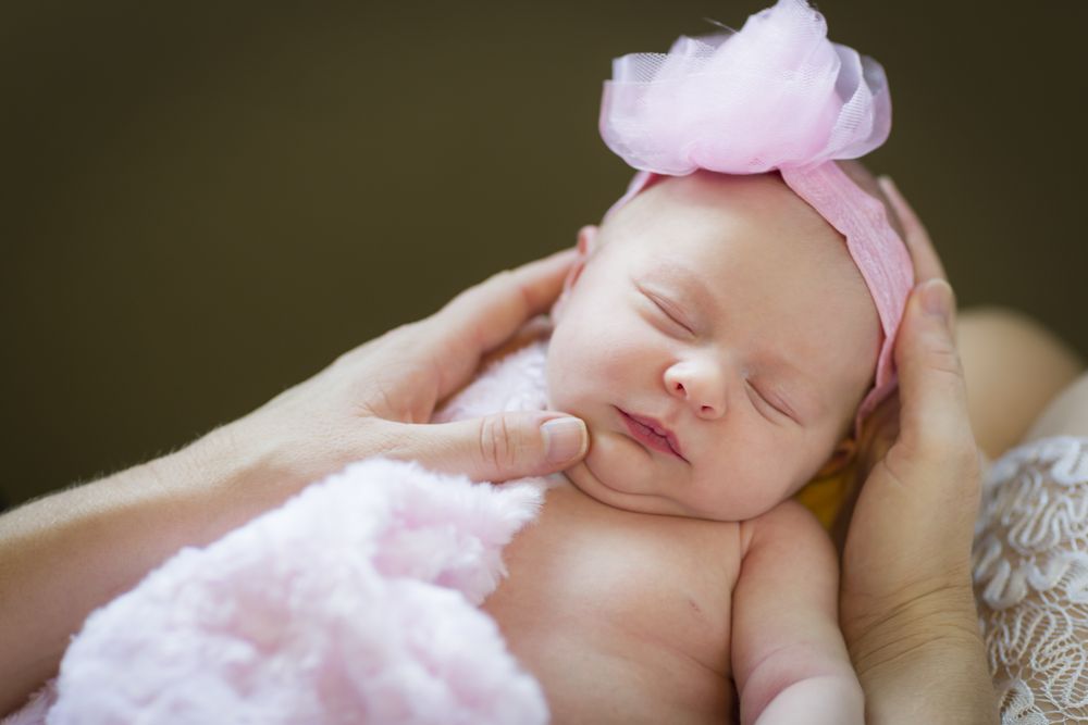 Hands of Parent Holding Her Newborn Baby Girl