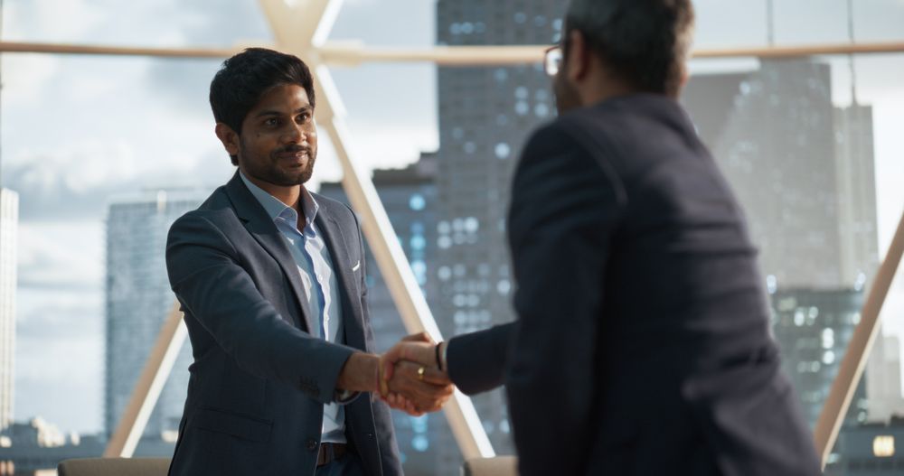 Two Men in Classic Suits Shake Hands and Celebrate Successful Partnership