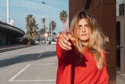 Charming woman with stretched out hand on street