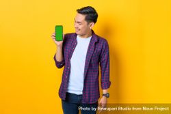Asian man holding smartphone with chroma key while looking at it 4AeOR4