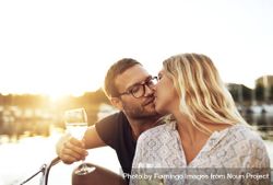 Couple kissing on a boat with wine glasses 4Bn9B4