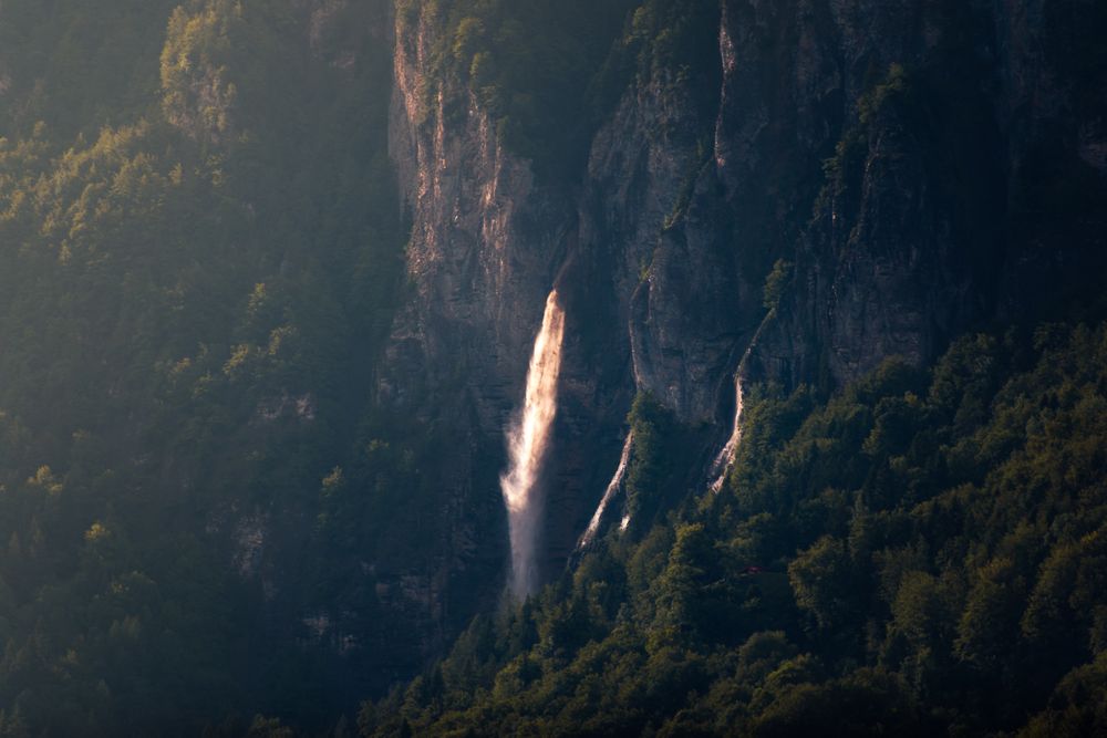 Majestic mountain waterfall on side of rock in sunny day