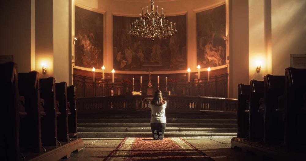 Back Symmetrical View: Christian Woman Getting on her Knees and Starting to Pray in a Church.
