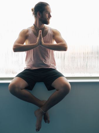 Man in mindfulness on window sill