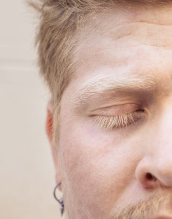 Close up portrait of a Latino man with albinism with closed eyes
