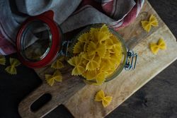 Top view of farfalle pasta in glass jar on kitchen counter