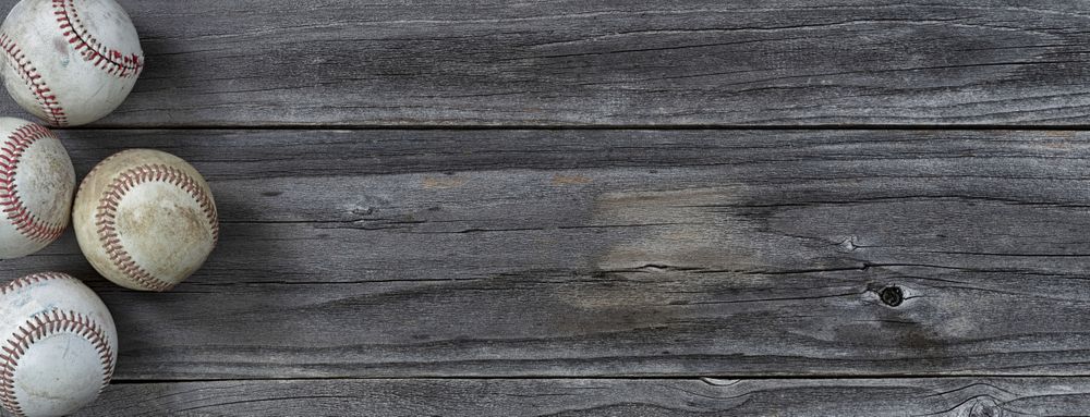 Used baseballs on vintage wooden background
