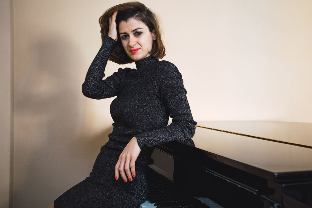 Young woman sitting at a piano posing