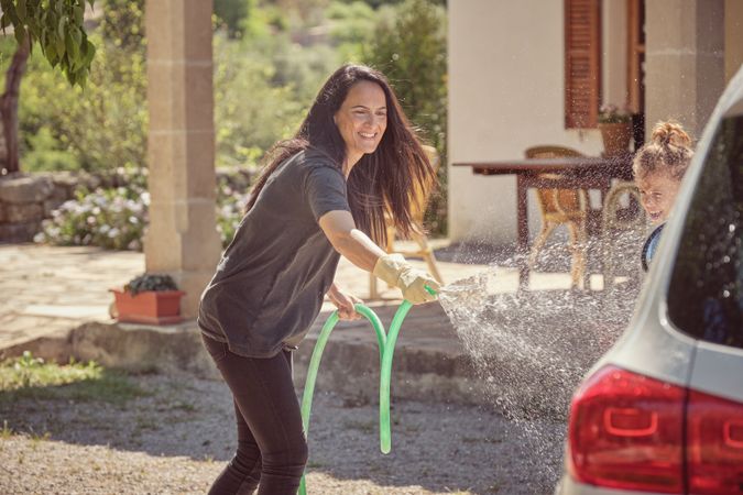 Happy woman with son washing car