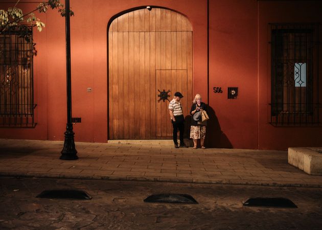 Man and woman standing outside of large door at night