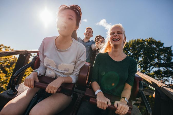 Enthusiastic young friends on roller coaster ride