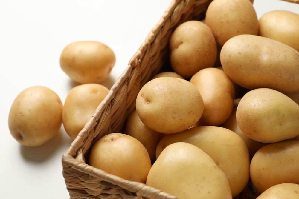 Top view close up of wooden box full of potatoes