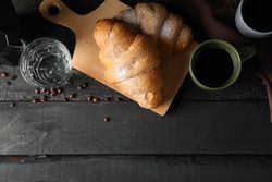 Composition with tasty croissants on wooden background, top view and copy space
