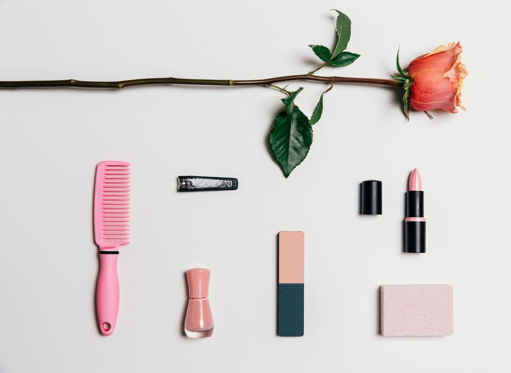 Feminine accessories in pink tones over plain background