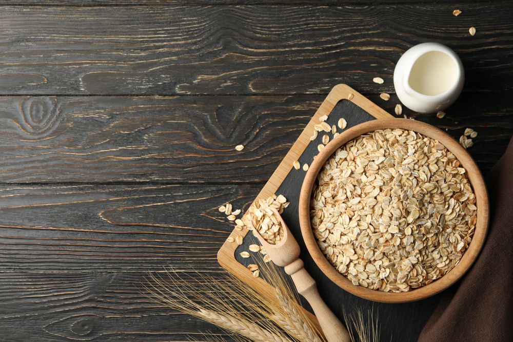 Composition with oatmeal flakes and milk on wooden background