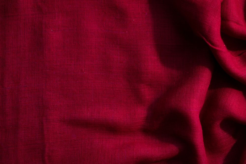 Red fabric wavy crumpled background texture with copy space.