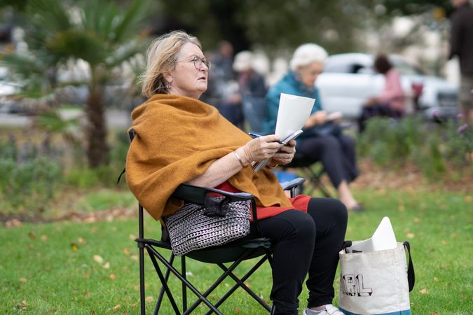 Woman looking up from her drawing in park