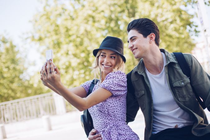 Happy young couple taking selfie in park