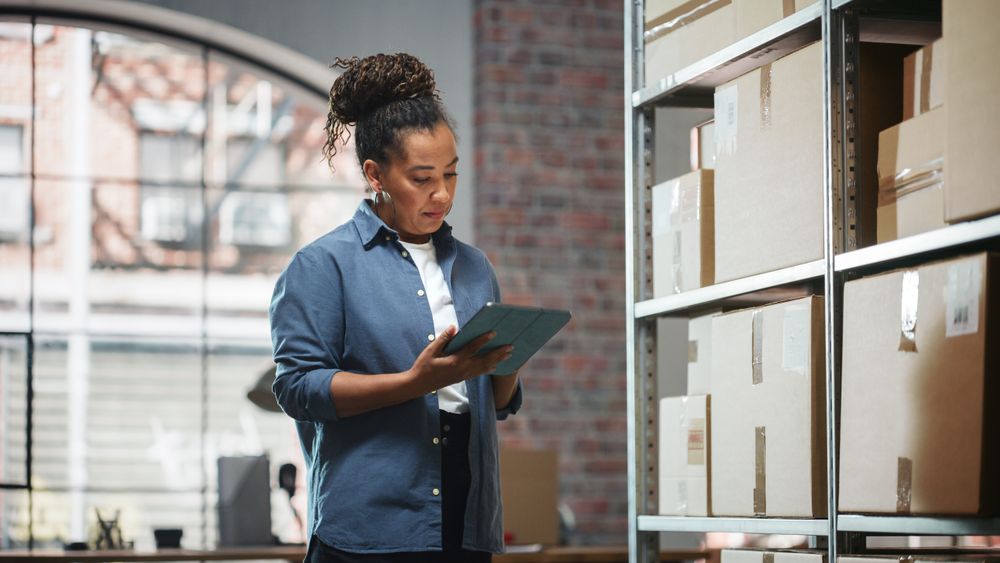 Inventory Manager Checks Stock, Writing in Clipboard Software on Tablet Computer.