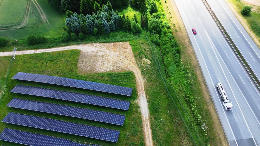 Aerial view of the A7 motorway in northern Germany with big solar panel areas close to the highway.