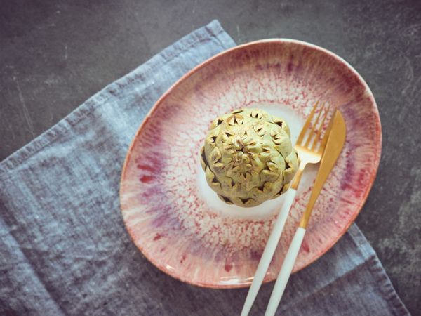 Artichoke on plate with cutlery