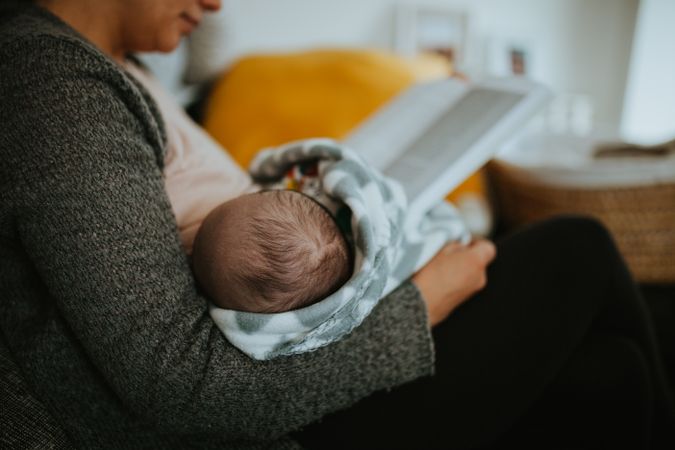 Mother reads and breast feeds
