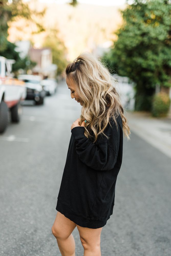 Side view of woman in dark sweater standing on road