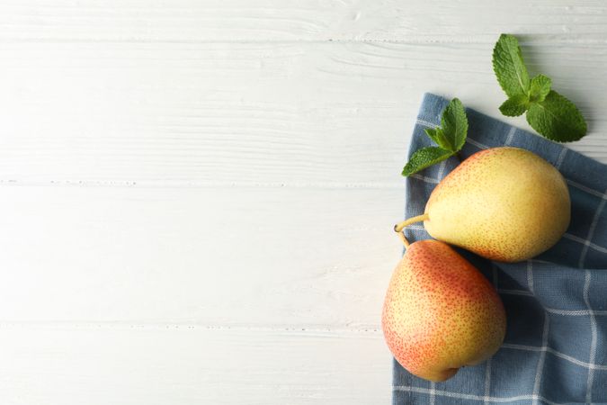 Pears, towel and mint on wooden background, top view