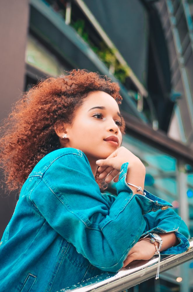 Girl with curly hair standing on balcony