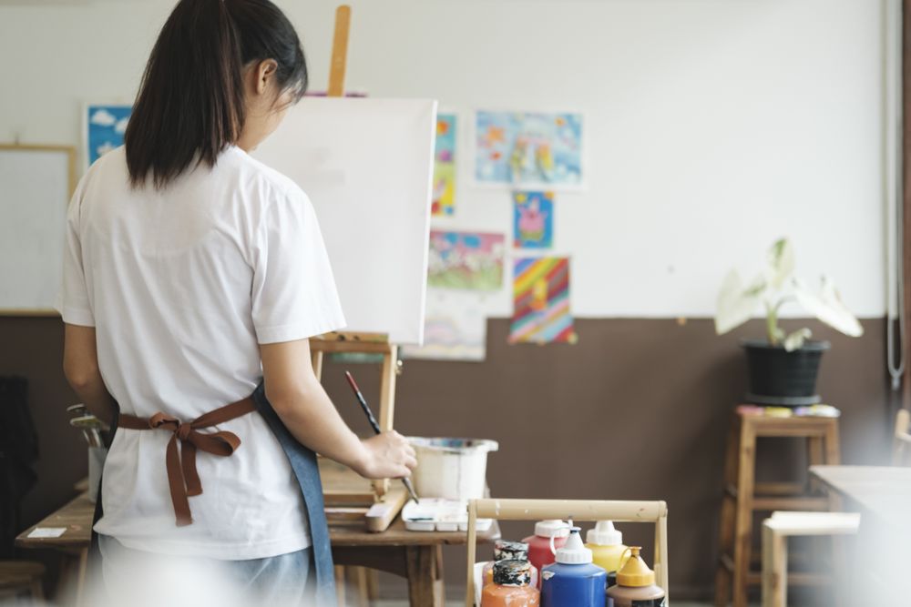 Crafting Inspiration: Female Artist Sketching and Painting in Workshop