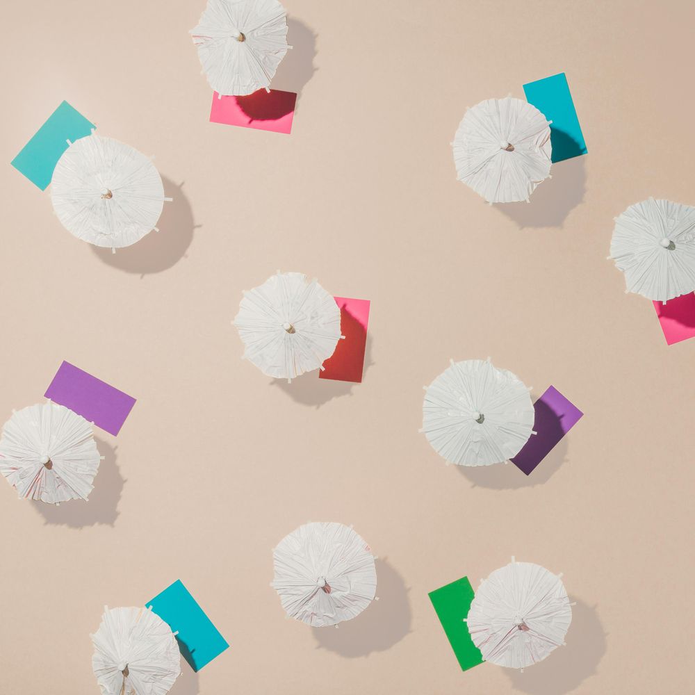 Aerial view of sun umbrellas and multicolored towels on sand