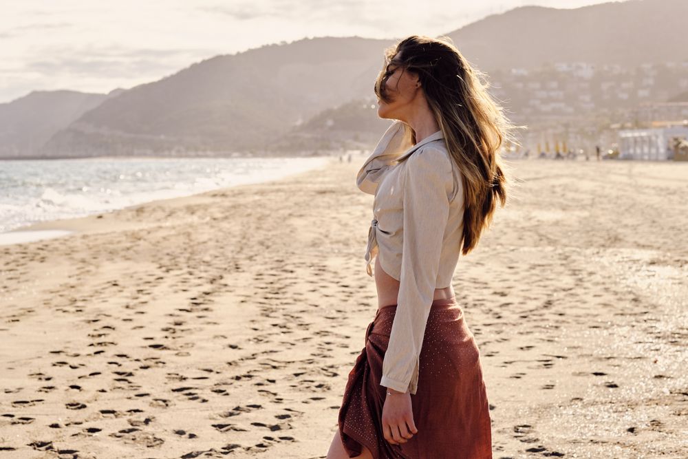 A fashion model at the beach before sunset